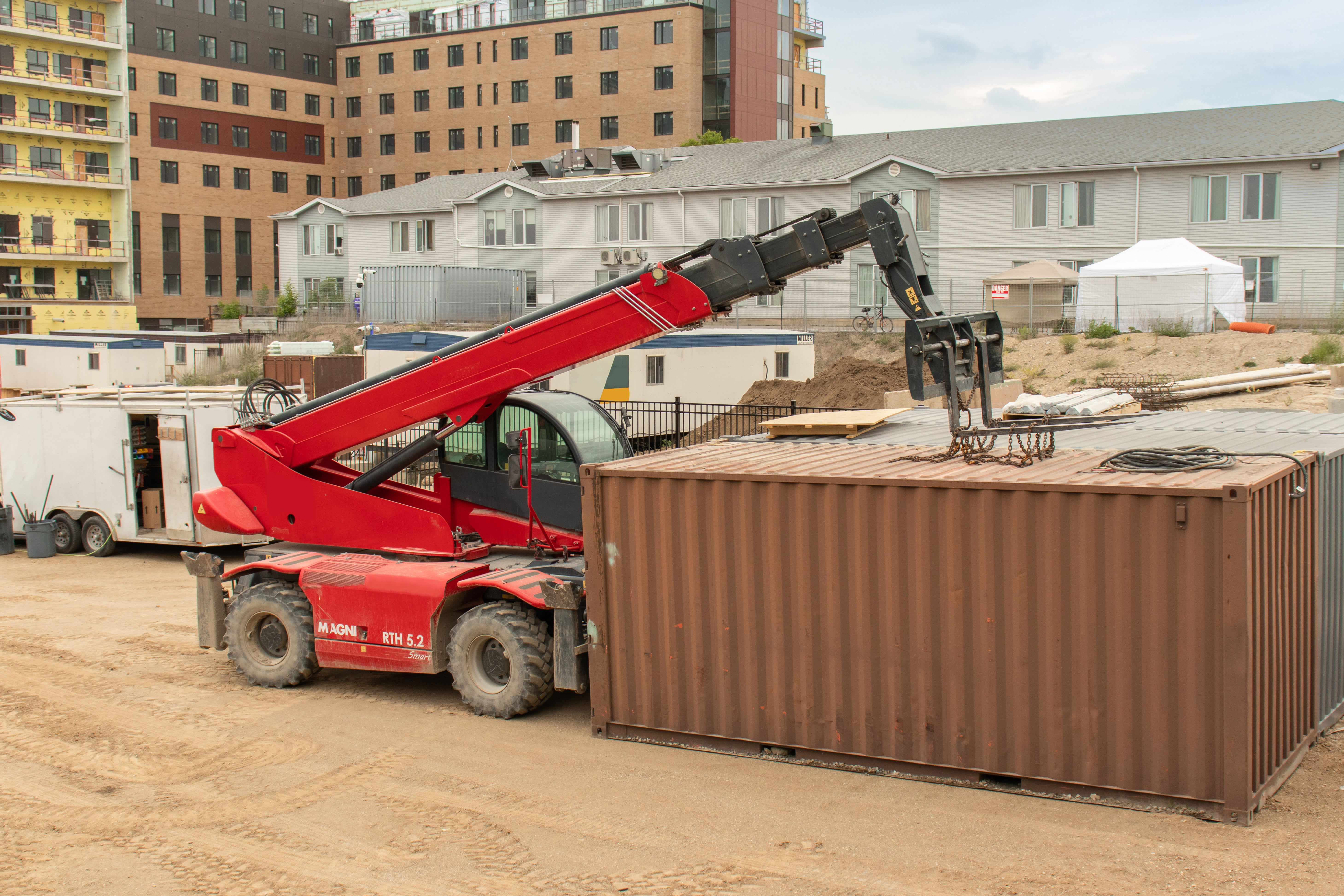 Telehandler with arm raised on construction site